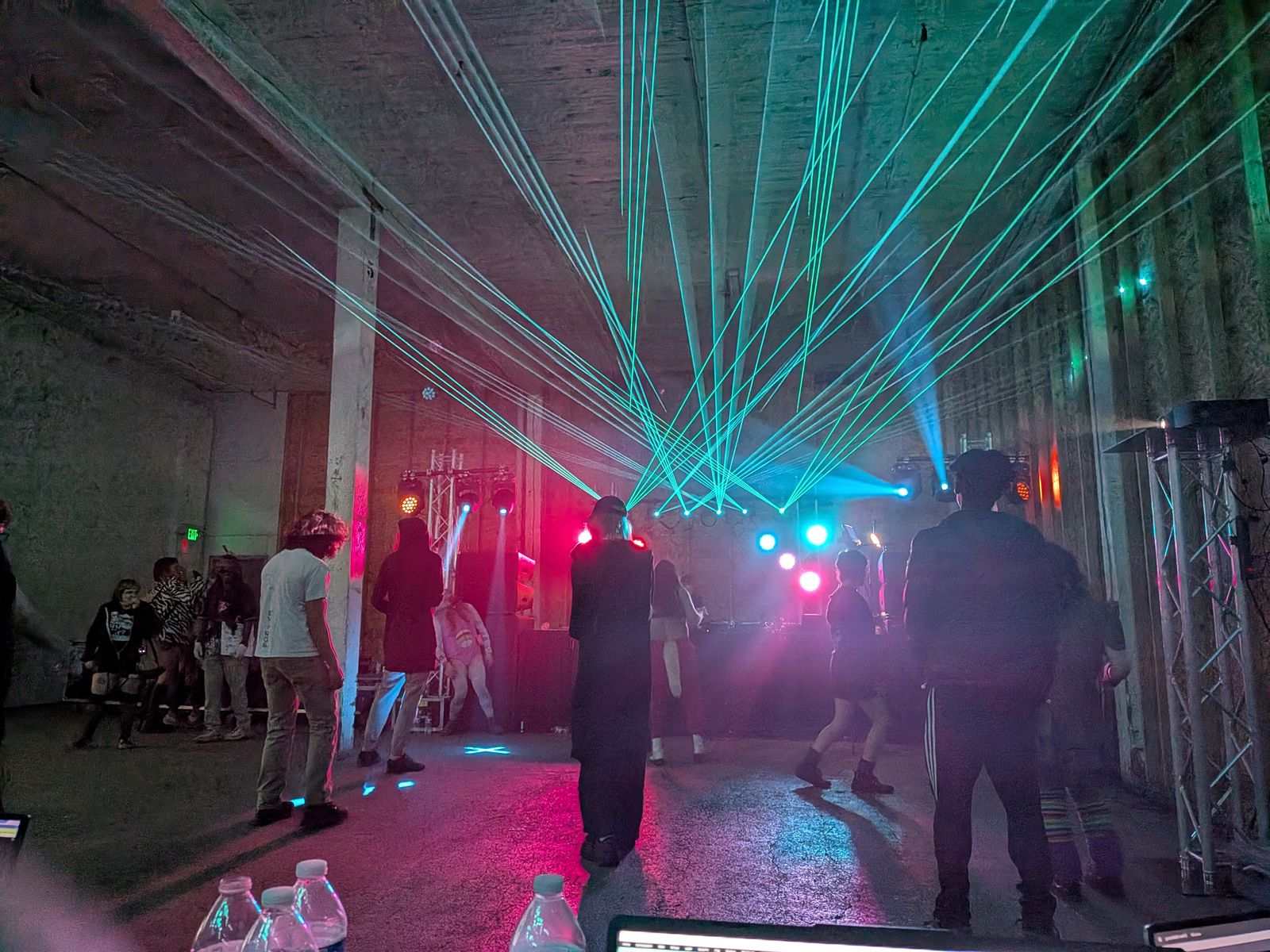 Warehouse dance night with a green laser fan and truss